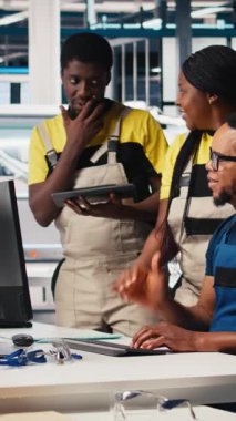 Dikey Video Meslektaşları, sürdürülebilir bir endüstriyel fabrikadaki bilgisayar istasyonundan güneş enerjisi teçhizatı çekiyorlar. Siyah mühendislik ekibi CAD yazılım ayarlamalarıyla ilgileniyor. Kamera.