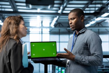 Veri merkezinde krom anahtar dizüstü bilgisayar kullanan bir mühendis, sunucu sanallaştırma stratejilerini inceliyor. Çalışanlar, sunucu küme düğümlerini yapılandırmak için izole ekran defteri kullanarak verimli iş akışlarını sürdürüyorlar