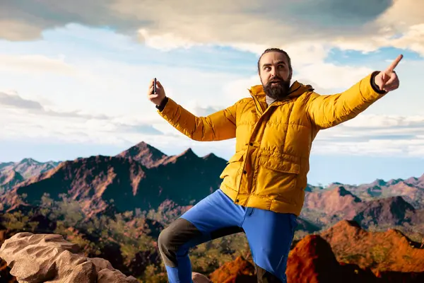 Doğa aşığının, akıllı telefonuyla dikkati dağıtıldığı için yürüyüş aktivitesini sosyal medyada belgelemesi memnuniyet verici. Dağ tepesindeki bir vlog için film çeken maceraperest bir etkileyicidir..