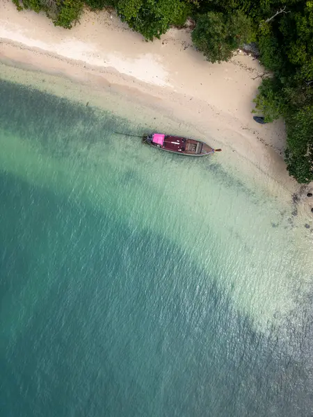 Tayland koyunda yelkenli tekneleri olan tropikal bir adanın havadan görünüşü sakin bir gölde sürüklenen yelkenli teknelerinin olduğu çarpıcı bir seyahat rotası. Palmiye ağaçları, altın plajlar ve turkuaz bir okyanus..