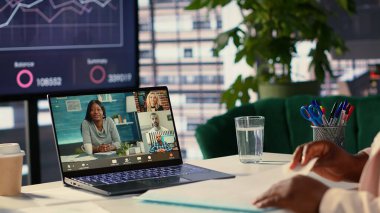 Afrikalı Amerikalı CEO şirketin geleceği hakkında çevrimiçi video konferansında hava tahminleri ile görüşüyor. Genel müdür konferansta danışma kuruluyla görüşüyor. Kamera A.