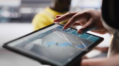 Fotovoltaik fabrikası çalışanı tablet üzerindeki güneş modülleri için CAD teknik çizimleri inceleyerek montaj sürecini inceliyor. Güneş paneli tasarımlarını geliştiren bir teknisyen. Kamera A.