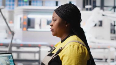 Mühendis modern fabrikada enerji optimizasyon yazılımı üzerinde çalışan PC 'deki güneş paneli sistemlerini ayarlıyor. Uzman, yüksek teknolojili otomatikleştirilmiş bir tesiste fotovoltaik operasyonları yönetiyor. Kamera B.