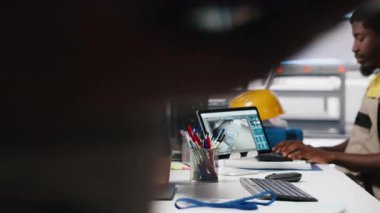 Afrika kökenli Amerikalı kadın çalışanlar, yenilenebilir enerji üretim endüstrisinde çalışarak çoklu güneş paneli tasarımlarını CAD yazılımı üzerinde test ediyorlar. Üretimi optimize eden kadın mühendis. Kamera A.