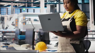 Photovoltaics fabrikası yöneticisi test denetimi için dizüstü bilgisayar kullanarak üretim sürecini inceliyor. Güneş panelinin çevre dostu yenilenebilir enerji konfigürasyonlarını geliştiren bir kadın. Kamera B.