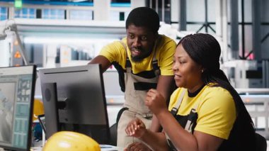 Yüksek teknolojili bir güneş paneli fabrikasında çalışan siyah mühendislik ekibi, dinlenme süresini ve kusursuz üretim sürecini azaltıyor. Teknisyenler güneş enerjisi üretimini optimize ediyorlar. Kamera A.