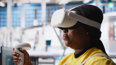 Fotovoltaik fabrikasındaki siyah mühendis arızalı sistemleri teşhis etmek için sanal gerçeklik ekipmanları kullanıyor. Kadın güneş panelleri fabrika işçisi denetleme için VR kulaklık kullanıyor, yüksek teknoloji. Kamera A.