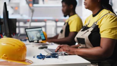 Yenilenebilir enerji tesisinde güneş enerjisi teknolojisini test eden siyah mühendis, yazılım sorunları ve performans ölçümlerine odaklanıyor. Çevre dostu endüstriyel operasyonları destekliyor. Kamera A.