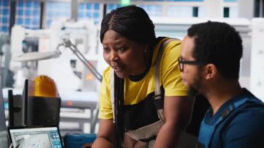 Mühendisler modern fabrikadaki güneş sistemi yazılımını izliyorlar, enerji üretimini denetleyen uzmanlardan oluşan bir ekip ve yüksek teknolojili bir fotovoltaik tesiste ekipman ayarlıyorlar. Kamera A.