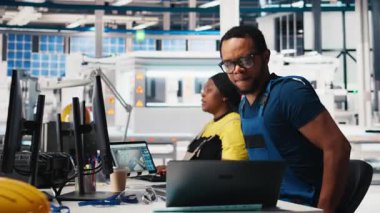 Siyah mühendis güneş sistemi parametrelerini yenilenebilir enerji tesisinde PC kullanarak endüstriyel iş istasyonuna giriyor. Teknisyen yazılım yönetimi yoluyla sürdürülebilir üretimi destekliyor. Kamera B.