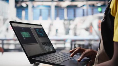 Güneş panelleri erkek işçi dizüstü bilgisayardaki performans verilerini analiz ediyor ve verimliliği optimize ediyor. Fotovoltaik fabrikası mühendisi, yenilikçi güneş pilleri dizaynı üzerinde çalışıyor, prototip, yüksek teknoloji. Kamera B.