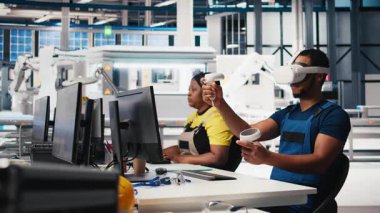 Güneş panellerindeki Afrikalı Amerikalı teknisyenler VR gözlük kullanarak tesis kuruyor CAD yazılımı kullanarak yerleşimleri optimize ediyorlar. Fotovoltaik fabrika işçisi sanal gerçeklik teknolojisini kullanarak düzenlemeler yapıyor. Kamera B.