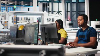 Çağrı merkezi teknisyeni güneş enerjisi fabrikasındaki bakım soruşturmalarını yürütüyor. Müşteri hizmetleri endüstriyel teknik destek bölümünde çalışıyor. Müşterilerle birlikte kulaklık takan Afrikalı Amerikalı bir operatör. Kamera B.