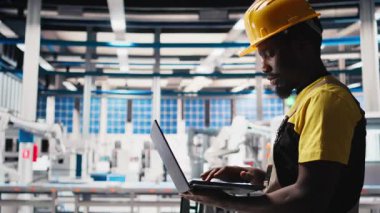 Güneş paneli fabrika üretim hatlarını izlemek için dizüstü bilgisayar kullanan bir mühendis sorunlu fotovoltaik ekipmanlarla sorunsuz üretim akışını sağlıyor. Alternatif enerji için otomasyon. Kamera B.