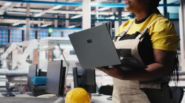 Fotovoltaik fabrikası mühendisi güneş paneli üretim hattının performans testini yapmak için dizüstü bilgisayar kullanıyor. Maliyet düşüşü için sürdürülebilir güneş enerjisi konfigürasyonlarını geliştiren teknisyen. Kamera B.