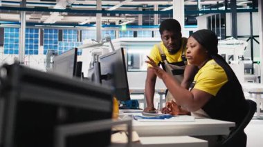 Siyahi mühendislerden oluşan bir ekip fabrikadaki güneş panelleri üretimini inceliyor ve üretim hattı için kalite kontrolü yapıyor. Alternatif enerji endüstrisi üzerinde çalışan uzmanlar. Kamera A.