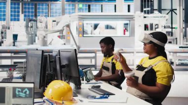 Dijital güneş pillerini monte etmek için VR kulaklık kullanan fotovoltaik fabrikası teknisyeni robot kolları aracılığıyla güneş panelleri yerleştiriyor. Sanal gerçekliği kullanarak güneş santrali makinelerini inceleyen kadın bir uzman. Kamera B.