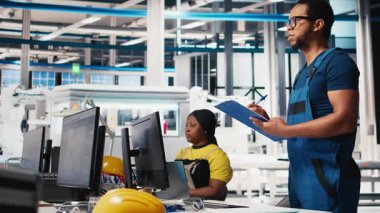 Fotovoltaik fabrikasındaki mühendisin portresi arızalı sistemlerin teşhisi için gerekli evrakları inceliyor. Güneş panelleri, dinlenme süresini azaltmak için inceleme dosyalarını okuyan fabrika işçisi. Kamera B.