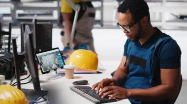 PC ve tabletle parametreleri karşılaştırarak fotovoltaik fabrikasındaki arızalı sistemleri araştıran bir mühendis. Siyahi adam güneş panellerini inceliyor üretim tesisi, yüksek teknoloji. Kamera A.