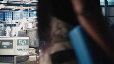 Afrikalı Amerikalı teknisyen, gelişmiş izleme ve üretim araçları kullanarak PC istasyonundaki yenilenebilir enerji ölçümlerini değerlendiriyor. Mühendis güneş enerjisinin hassasiyetini geliştiriyor. Kamera B.