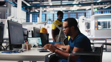 Özürlü siyah mühendis güneş panelleri üreterek yüksek teknoloji fabrikasında çevre dostu yenilenebilir enerji üretiyor. Tekerlekli sandalye deneme yazılımı teknisyeni. Kamera B.