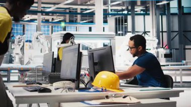 Afrikalı Amerikalı teknisyen güneş pillerinin performans raporlarını PC üzerinden analiz ediyor, çevre dostu yenilenebilir enerji üzerine odaklanıyor. Çalışan sürdürülebilirliği desteklemek için fotovoltaik çıktıyı izler. Kamera A.