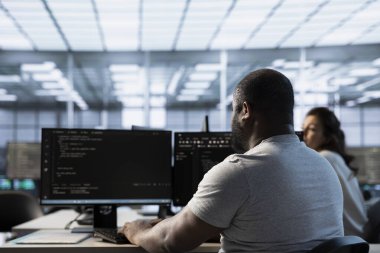 Sunucu çiftliğindeki teknisyen bilgisayarlara yapılan saldırılarla tehdit edilen verileri koruyor. Afro-Amerikan profesyonel bilişim yazma kodu, veri merkezini yetkisiz erişimden korumak