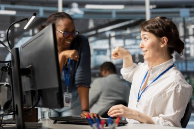 Happy sunucu merkezi ekip lideri operasyonları tamamladıktan sonra işçiyle yumruk tokuşturuyor. Dengeli performans göstergelerini kontrol ettikten sonra veri merkezindeki mühendisi kutlayan neşeli yönetici