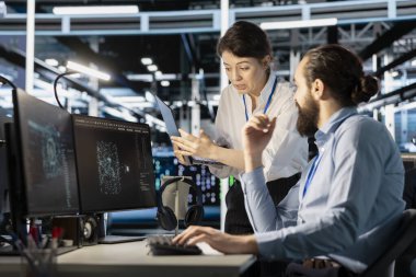 Mühendislik ekibi sunucu merkezinde beyin fırtınası yapıyor. Simülasyonlar için yapay zeka teknolojisini kullanıyor. Veri merkezi iş arkadaşları veri tabanından bilgi almak ve otomatik platformları açmak için algoritmaları kodluyor, işbirliği yapıyor