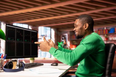 Heyecanlı borsacı hisse senedi satarak ve kârını maksimuma çıkararak para kazanıyor, mutlu oluyor. Afro-Amerikan yatırımcı, borsadan kazanılan mali kazancı kutluyor.