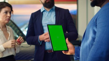 Satış elemanı müşterilerine yeşil ekran tabletinde araba modellerini gösteriyor, tavsiyelerde bulunuyor. Showroom temsilcisi Chroma Key cihazındaki müşterilere finansman seçenekleri sunar, Kamera A