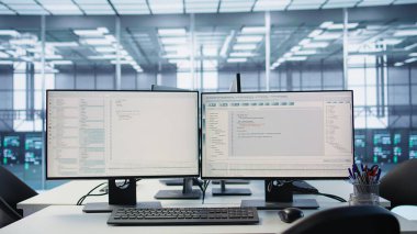 Boş yüksek teknoloji veri merkezindeki bilgisayarlar donanım enerji tüketimini izliyor. Sunucu odasındaki potansiyel sistem hatalarını kontrol etmek için kullanılan masadaki bilgisayar monitörleri, ekran görüntüsü