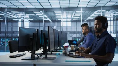 Klavyede veri merkezi yönetimi, donanımı yapılandırarak şirket ağ altyapısını koruyor. Sunucu merkezindeki Afrikalı Amerikalı işçi optimal sistem performansını garantiliyor, kamera A