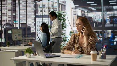 Genel müdür akıllı telefonunda bir büyüme planından bahsediyor, proje yönetimi görevleri üzerinde çalışırken bir müşteri araması yapıyor. CEO verimlilik için cep telefonuyla görüşmeler yapıyor. Kamera B.