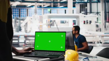 Photovoltaics fabrikası uzman sistem ayarları yeşil ekranda. Yönetici, güneş panelleri üretim tesisinde dizüstü bilgisayar üzerinde çalışıyor. Kamera B.