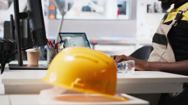 Erkek uzman makine parametrelerini güneş paneli üretimi için ayarlıyor, yüksek teknoloji üretim tesisinde çalışıyor. Siyah mühendis bilgisayarda teknik verileri analiz ediyor. Kamera A.