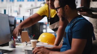 Photovoltaics tesis çalışanları güneş panellerini montaj hatlarına yerleştiren robotların performansını değerlendiriyor. Tüm siyah takımlar üretim sürecine bilgisayarda, güneş santralinde bakıyor. Kamera A.