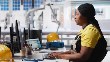 Siyah teknisyenlerden oluşan bir ekip fabrikada üretilen güneş panellerini inceliyor ve üretim hattı için kalite kontrolü yapıyor. Yenilenebilir enerji endüstrisi üzerinde çalışan mühendisler. Kamera A.