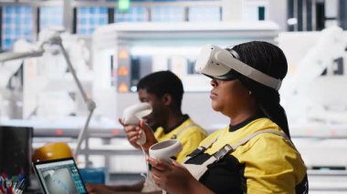 Fotovoltaik fabrikası mühendisi alternatif enerji jeneratörlerinin modellerini yapmak için VR teknolojisini kullanıyor. Güneş panelleri kadın çalışanları sanal gerçeklik teçhizatı kullanarak güvenli güneş hücreleri inşa ediyorlar. Kamera A.