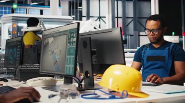 Siyah mühendis güneş paneli montaj yazılımında tanısal kontroller yaparak üretim sürecini ve güneş pillerini alternatif enerji için optimize ediyor. Yüksek teknoloji modern fabrika. Kamera B.