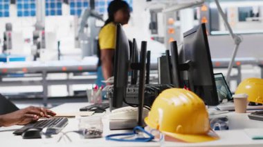 Afrika kökenli Amerikalı endüstriyel teknisyen güneş enerjisi tesislerindeki sistem sağlığını üretim işlemleri için yazılım araçları kullanarak değerlendiriyor. İşçi yeşil enerji için fotovoltaik ekipman üretiyor. Kamera A.