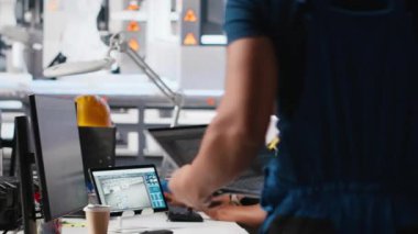 Siyah mühendis güneş sistemi parametrelerini yenilenebilir enerji tesisinde PC kullanarak endüstriyel iş istasyonuna giriyor. Teknisyen yazılım yönetimi yoluyla sürdürülebilir üretimi destekliyor. Kamera A.