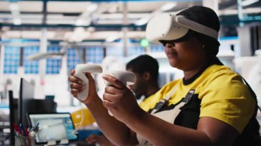 Fotovoltaik fabrikası çalışanı sanal gerçeklik teçhizatı kullanarak sistem performansını gözlemliyor. Güneş panelleri üretim tesisi uzmanı enerji üretimini izlemek için VR kulaklığı kullanıyor. Kamera B.