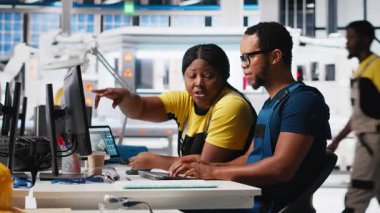 Fabrika işçileri analitik araçlar ve CAD yazılımı kullanarak PC 'de güneş enerjisi sistem tanılarını kontrol ediyorlar. Teknisyenler yenilenebilir enerji için arızalar tespit edip otomasyonu inceliyorlar. Kamera A.