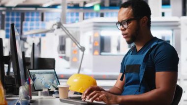 Güneş enerjisi uzmanı, araştırma ve yenilik odaklı çevre dostu fabrikada tasarım modellerini güncelliyor. Erkek işçi dijital sistemler kullanarak sürdürülebilir endüstriyel büyümeyi destekliyor. Kamera A.