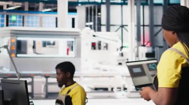 Afrika kökenli Amerikalı kadın çalışanlar, yenilenebilir enerji üretim endüstrisinde çalışarak çoklu güneş paneli tasarımlarını CAD yazılımı üzerinde test ediyorlar. Üretimi optimize eden kadın mühendis. Kamera B.