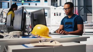 Güneş enerjisi uzmanı, araştırma ve yenilik odaklı çevre dostu fabrikada tasarım modellerini güncelliyor. Erkek işçi dijital sistemler kullanarak sürdürülebilir endüstriyel büyümeyi destekliyor. Kamera B.