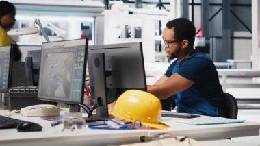 Afrikalı Amerikalı teknisyen güneş pillerinin performans raporlarını PC üzerinden analiz ediyor, çevre dostu yenilenebilir enerji üzerine odaklanıyor. Çalışan sürdürülebilirliği desteklemek için fotovoltaik çıktıyı izler. Kamera A.