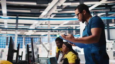 Güneş paneli fabrikasının yöneticisi potansiyel arıza sistemlerini araştırıyor, evrak okuyor ve kullanım kılavuzlarını okuyor. Müfettişler kesintisiz üretimi sağlıyorlar, kesintileri azaltıyorlar. Kamera B.