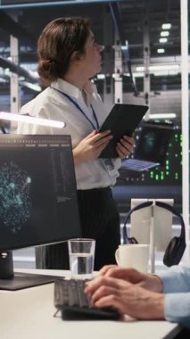 Ekranda nöral ağ algoritmasını inceleyen veri bilimcisini denetleyen dikey video sunucu merkez denetleyicisi. Yapay zeka altyapısındaki performans panellerini inceleyen yönetici